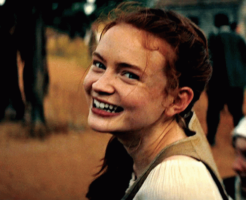 A Woman With Red Hair And Freckles Is Smiling GIF