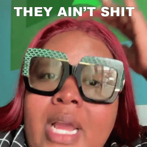 A Woman With Red Hair And Glasses Is Making A Funny Face And Saying They Ain 'T Shit . GIF