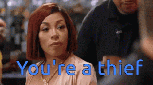 A Woman With Red Hair And The Words You 'Re A Thief Behind Her GIF