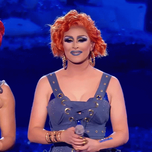 A Woman With Red Hair Holds A Microphone In Her Hand GIF