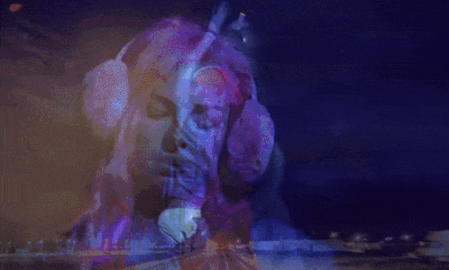A Woman With Red Hair Is Dancing In A Dark Room GIF