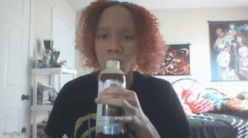 A Woman With Red Hair Is Drinking From A Bottle That Says Imgflip On It GIF