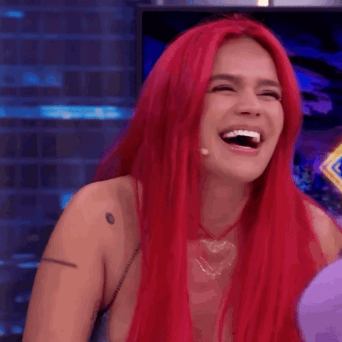 A Woman With Red Hair Is Laughing With Her Mouth Wide Open GIF