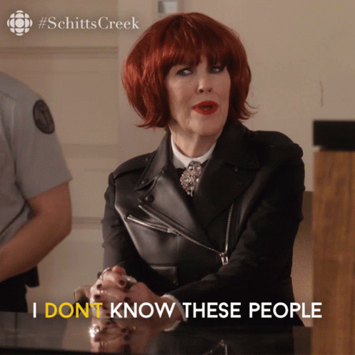 A Woman With Red Hair Is Sitting At A Table And Says " I Dont Know These People " GIF
