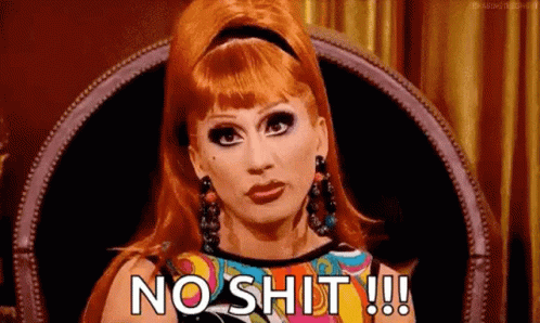 a woman with red hair is sitting in a chair and saying `` no shit !!! '' .