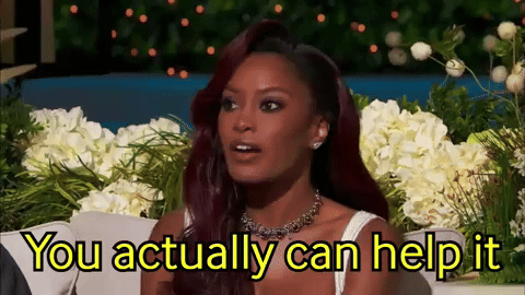 A Woman With Red Hair Is Sitting In Front Of Flowers And Says You Actually Can Help It GIF