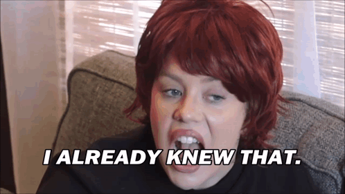 A Woman With Red Hair Is Sitting On A Couch And Says " I Already Knew That " GIF