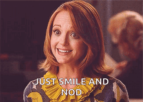 A Woman With Red Hair Is Smiling And Says Just Smile And Nod GIF