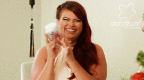 A Woman With Red Hair Is Smiling In Front Of A Logo For Clorofitum GIF