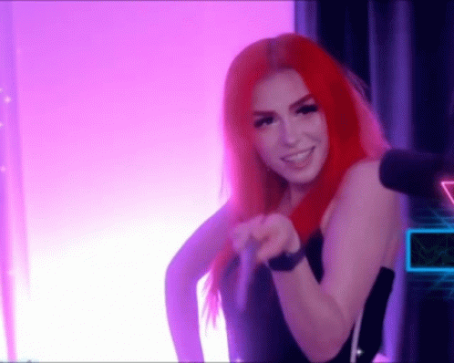 A Woman With Red Hair Is Standing In Front Of A Microphone . GIF