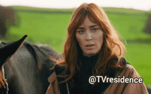 A Woman With Red Hair Is Standing Next To A Black Horse With The Words @Tvresidence Written Below Her GIF
