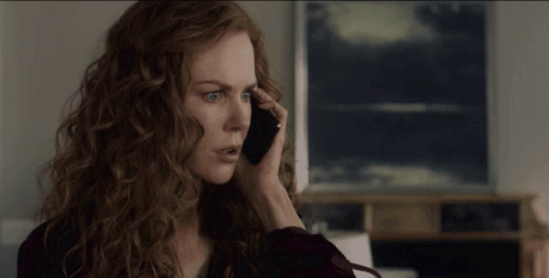 A Woman With Red Hair Is Talking On Her Cell Phone GIF