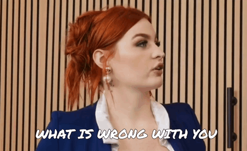 a woman with red hair is talking to someone and the words what is wrong with you are above her