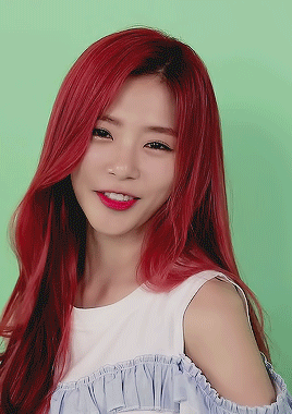 A Woman With Red Hair Is Wearing A Blue And White Off The Shoulder Top GIF