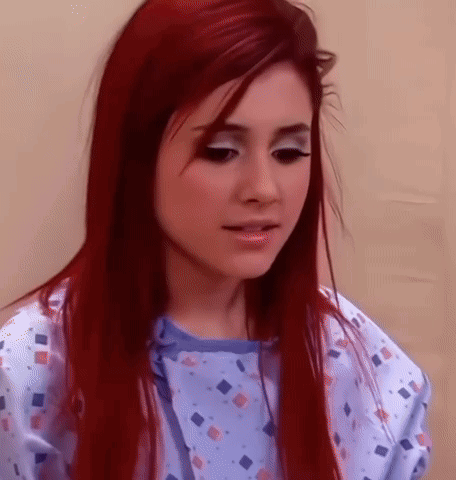 A Woman With Red Hair Is Wearing A Blue Hospital Gown GIF