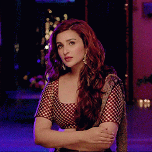 A Woman With Red Hair Is Wearing A Checkered Top GIF