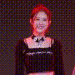A Woman With Red Hair Is Wearing A Choker And A Black Crop Top . GIF