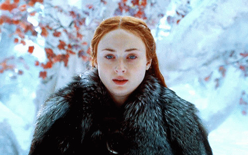 A Woman With Red Hair Is Wearing A Fur Coat GIF
