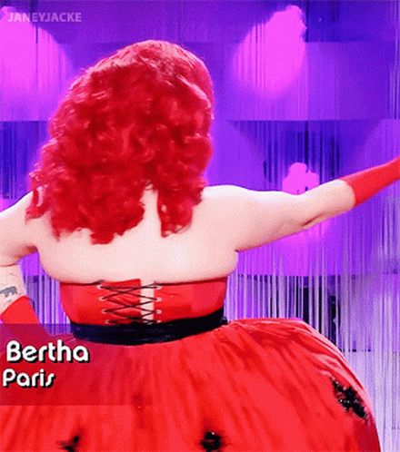 A Woman With Red Hair Is Wearing A Red Dress That Says " Paris " GIF