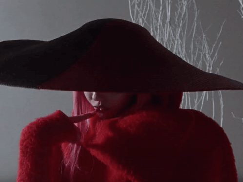a woman with red hair is wearing a red hat