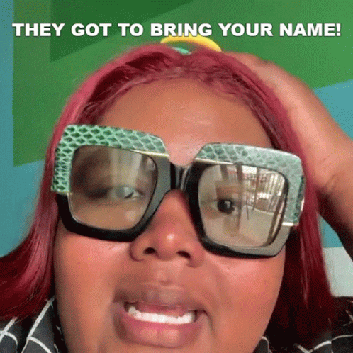 A Woman With Red Hair Is Wearing Sunglasses And Holding Her Hand To Her Head . GIF