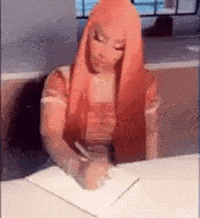 A Woman With Red Hair Is Writing On A Piece Of Paper . GIF