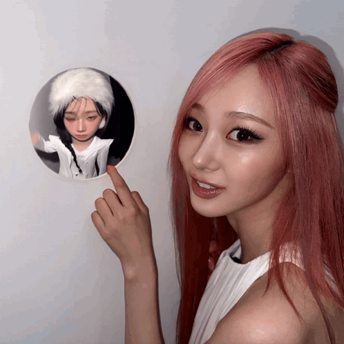 A Woman With Red Hair Points To A Picture Of A Girl GIF