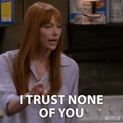 A Woman With Red Hair Says " I Trust None Of You " In Front Of A Laundry Machine . GIF