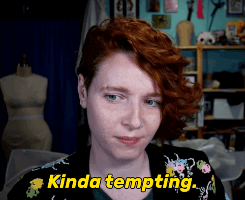 A Woman With Red Hair Says " Kinda Tempting " In Yellow Letters GIF