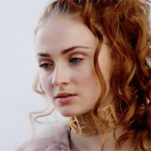 A Woman With Red Hair Wearing A Gold Choker GIF