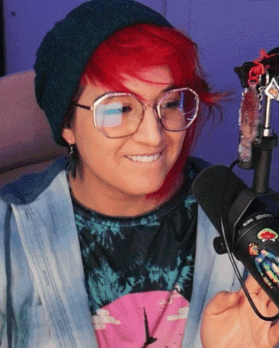 A Woman With Red Hair Wearing Glasses And A Beanie GIF