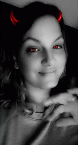 A Woman With Red Horns On Her Head Is Smiling GIF