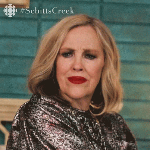 A Woman With Red Lipstick And A #Schitts Creek Logo GIF