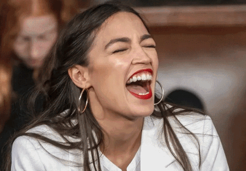 A Woman With Red Lipstick And Hoop Earrings Is Laughing With Her Eyes Closed GIF
