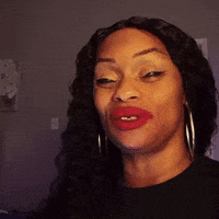 a woman with red lipstick and hoop earrings is making a funny face .