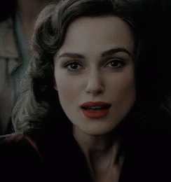 A Woman With Red Lipstick Is Smiling And Looking At The Camera GIF