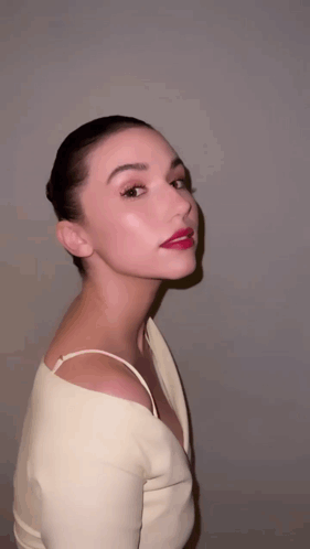 A Woman With Red Lipstick On Her Lips Is Wearing A Very Revealing Top GIF