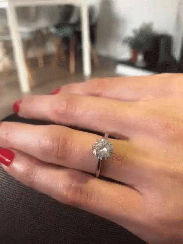 A Woman With Red Nails Is Wearing A Diamond Ring On Her Left Hand GIF