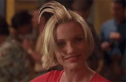 A Woman With Short Blonde Hair Is Making A Funny Face . GIF