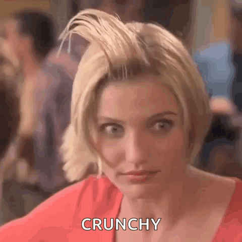 A Woman With Short Blonde Hair Is Making A Funny Face And Saying Crunchy . GIF