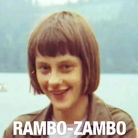 A Woman With Short Brown Hair Is Smiling With The Words Rambo-Zambo Behind Her GIF
