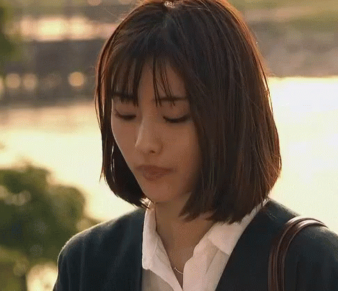 A Woman With Short Hair Is Wearing A Suit And A White Shirt And Is Looking Down . GIF