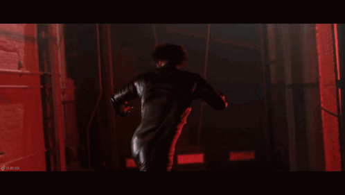 A Woman With Spikes On Her Body Is In A Dark Room With Red Lights GIF