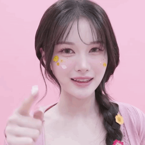 A Woman With Stickers On Her Face Is Pointing Her Finger GIF