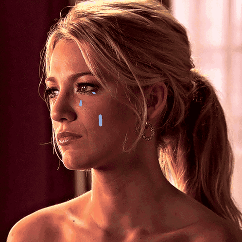 A Woman With Tears Running Down Her Face Is Wearing Earrings GIF