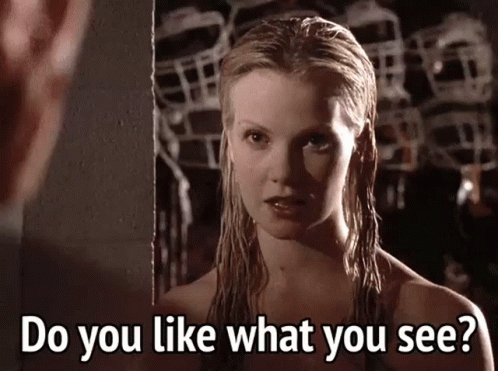 a woman with wet hair is looking at herself in the mirror and says do you like what you see .