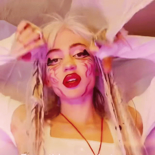 A Woman With White Hair And Red Lips Is Wearing A White Top GIF