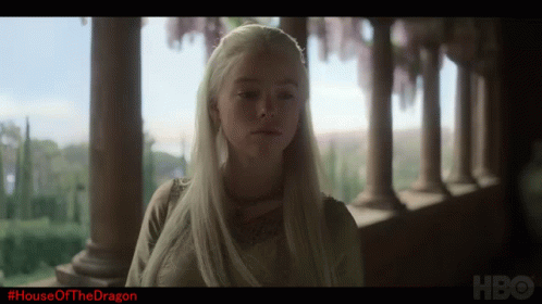 A Woman With White Hair Is Standing In Front Of A Row Of Columns And The Words House Of The Dragon Are On The Bottom GIF