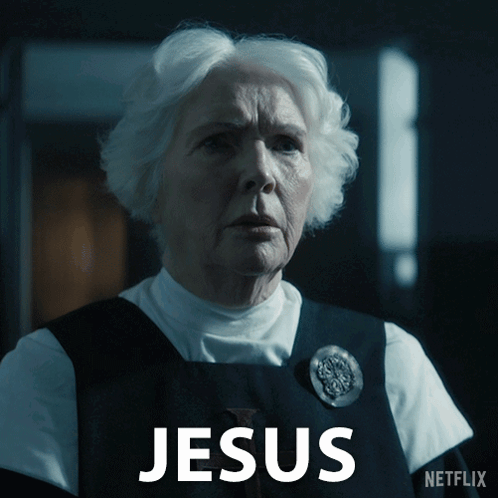 A Woman With White Hair Is Standing In Front Of A Sign That Says Jesus On It GIF