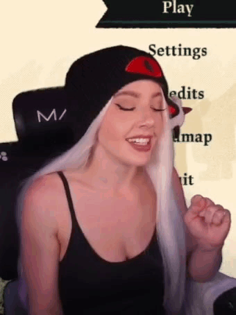 A Woman With White Hair Is Wearing A Black Tank Top And A Black Hat . GIF